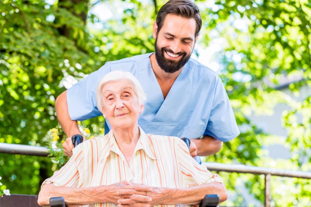 Nurse pushing senior woman in wheelchair