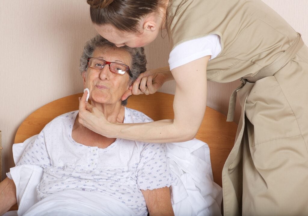 Young social work assistant takes care of a senior woman
